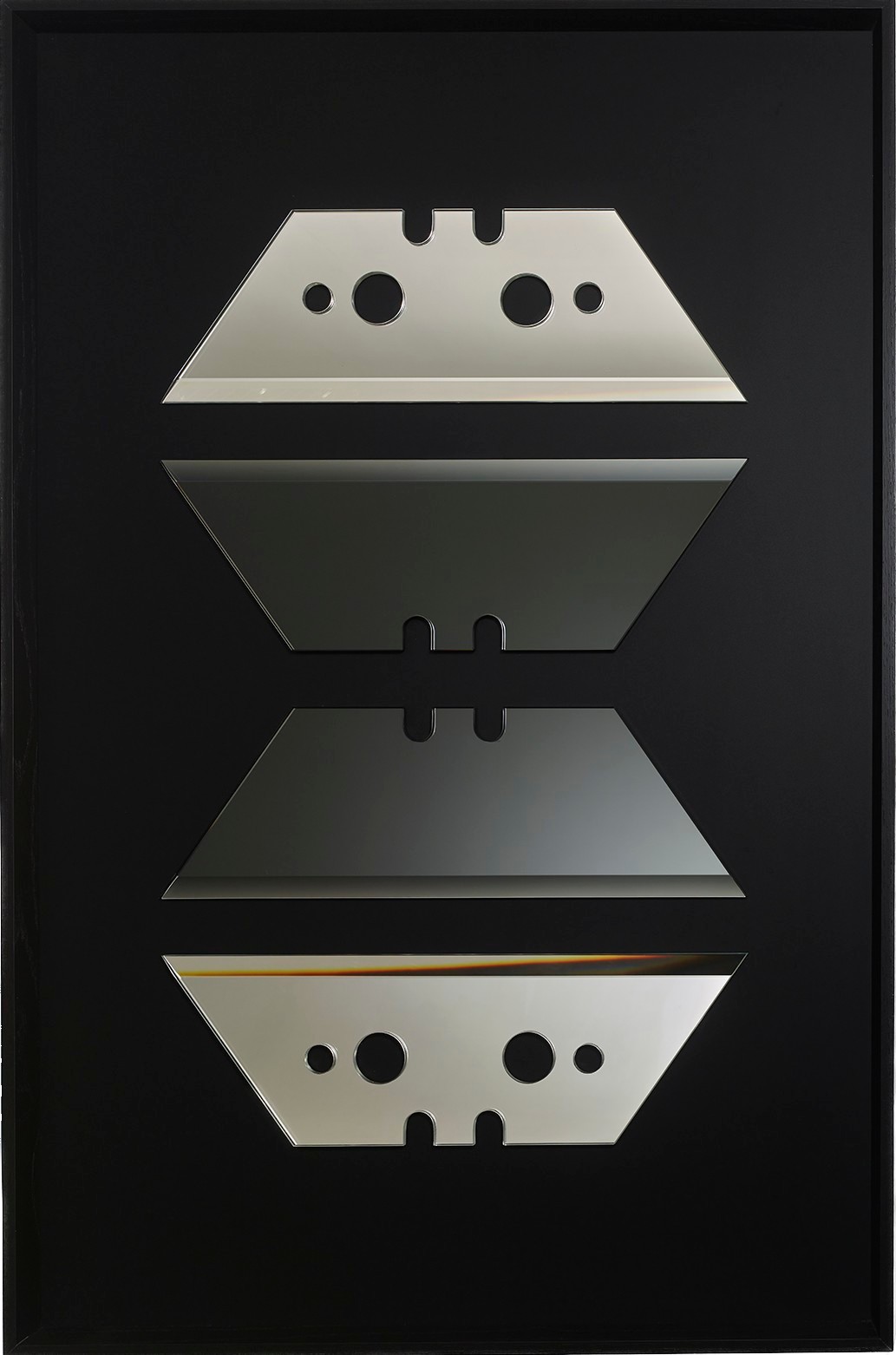 Troisième panneau : quatre lames trapézoïdales de cutter en miroir empilées en symétrie, les deux lames centrales en miroir gris