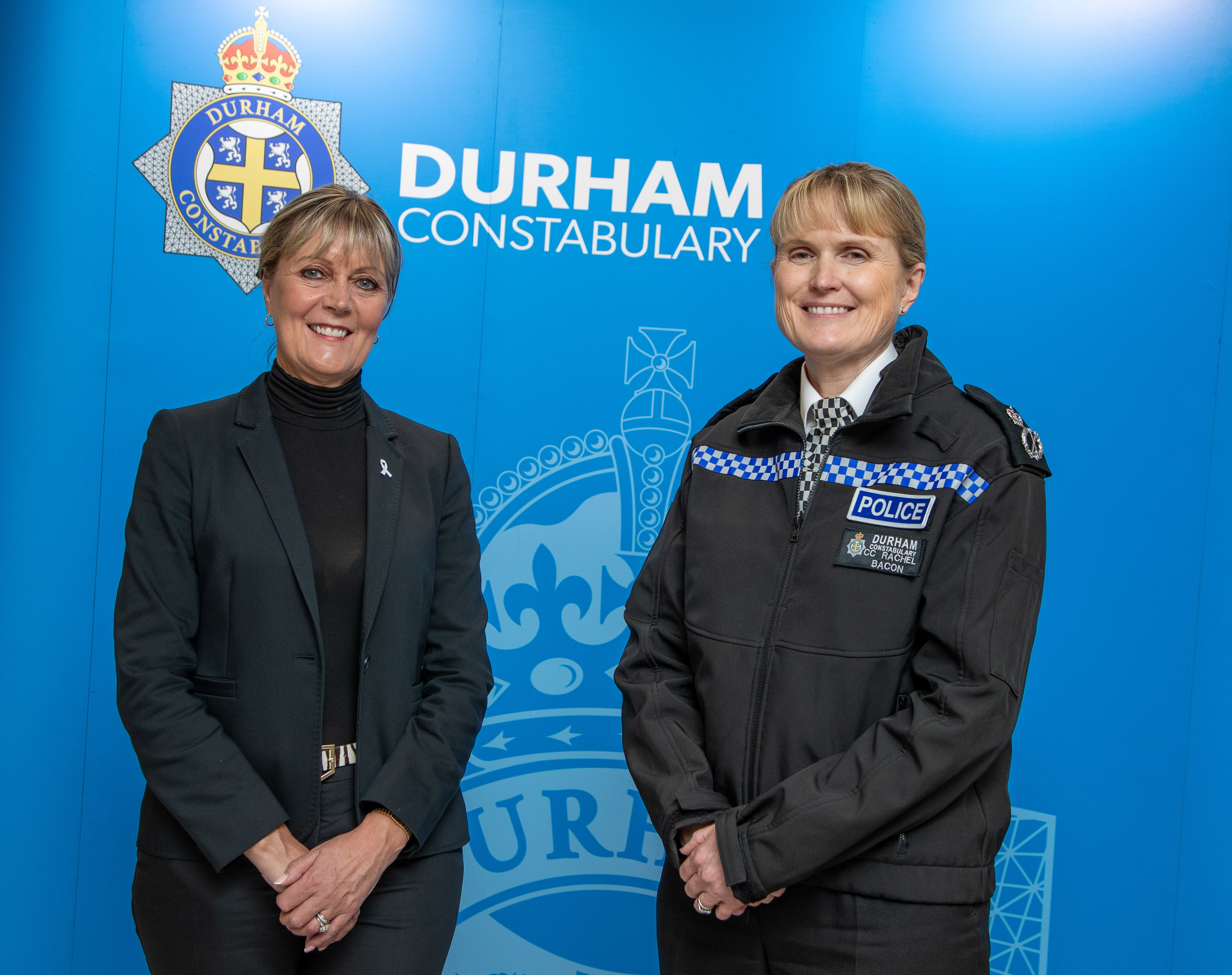 Two women smiling in front of Durham Constabulary sign, one in police uniform.