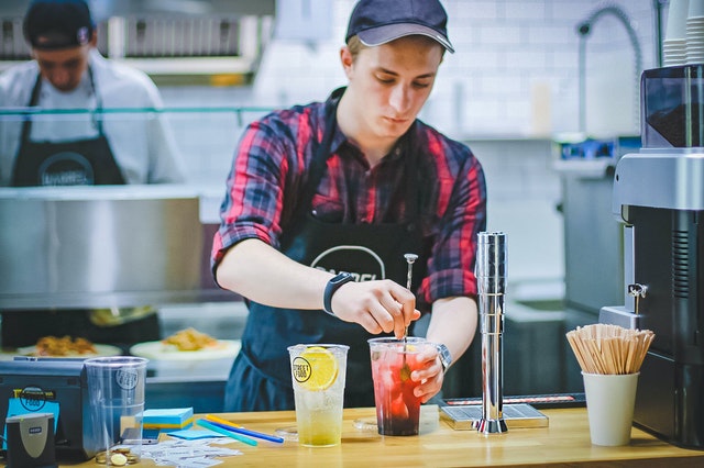 employee mixing drink in kitchen