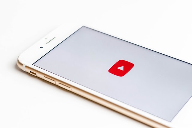 YouTube icon on white smartphone screen