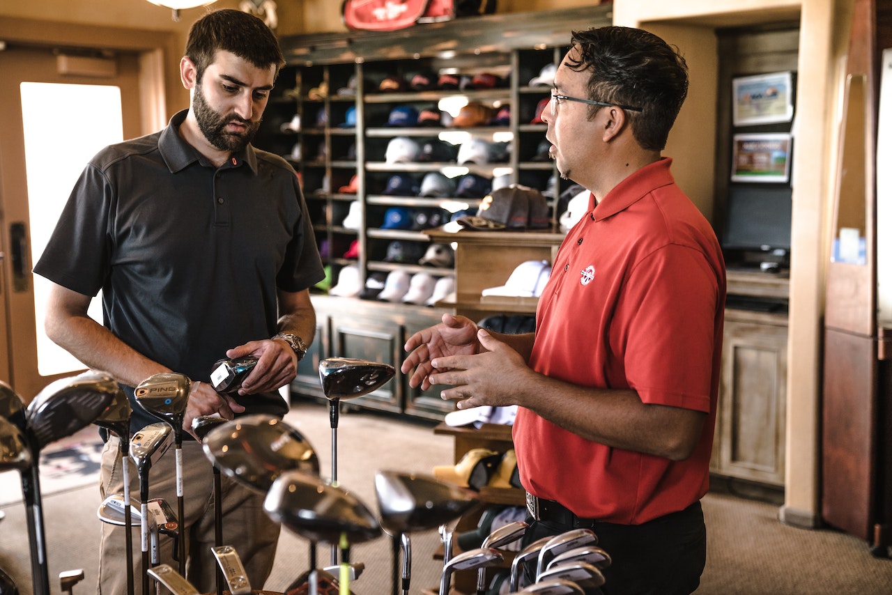 Golf store employee helping customer