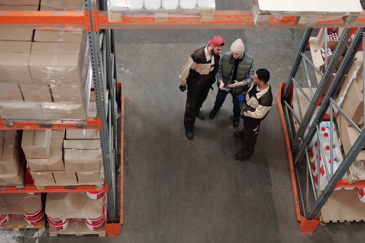 A group of men checking an inventory check in a warehouse