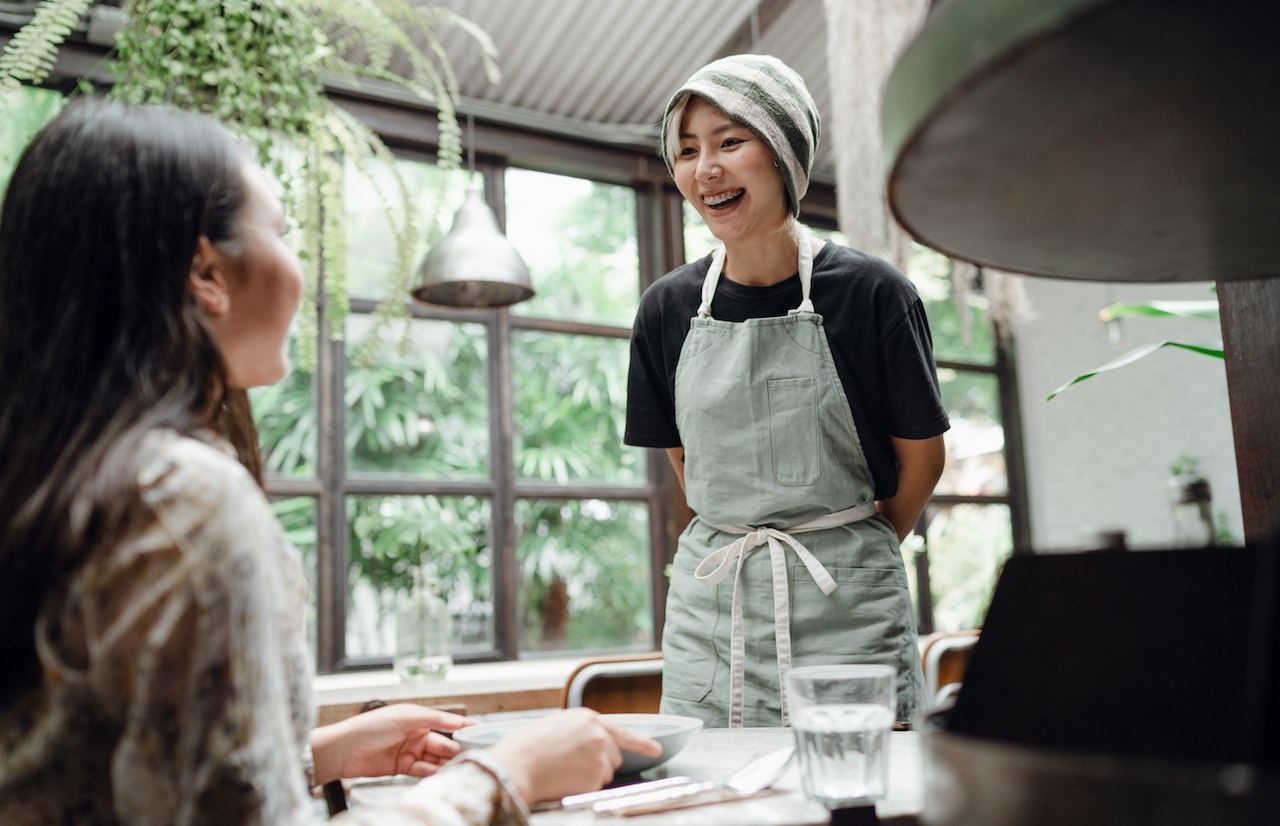 A cafe waitress talking to a loyal customer