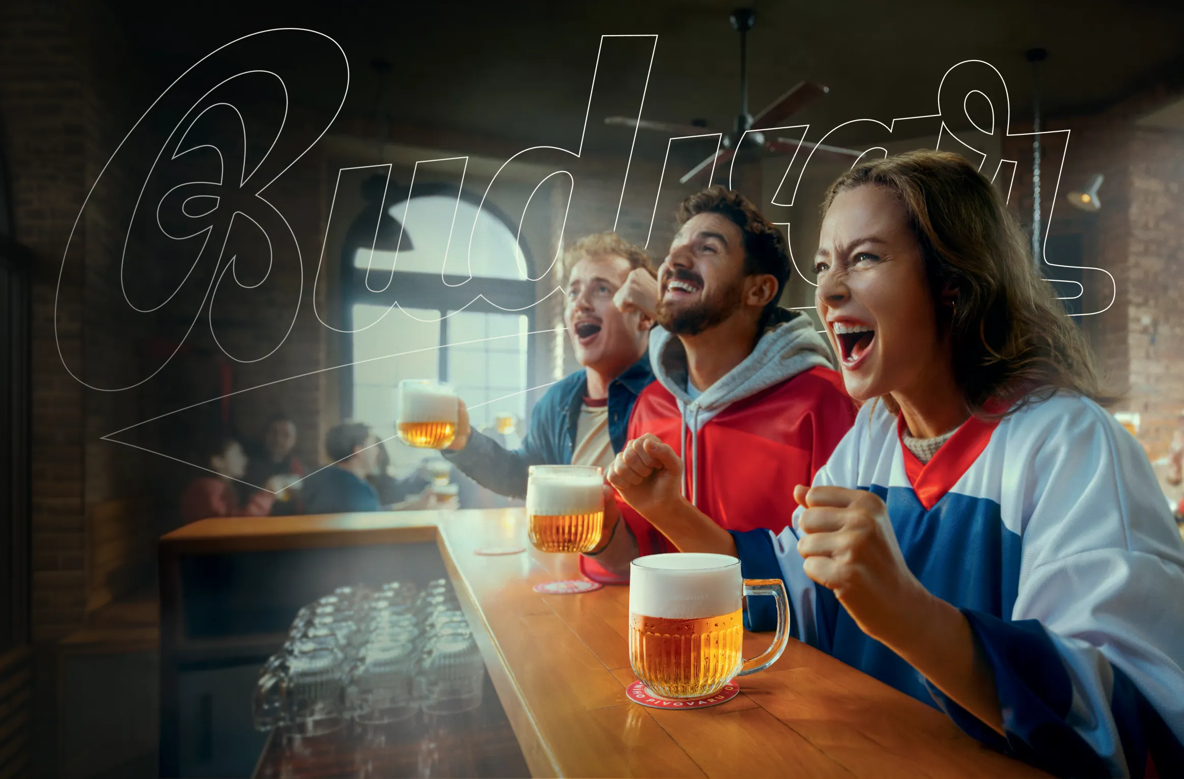 3 sportovní fanoušci v českých dresech a pivem Budvar v restauraci