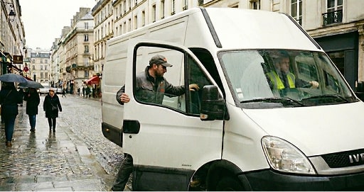 Homme montant à bord d'un camion blanc