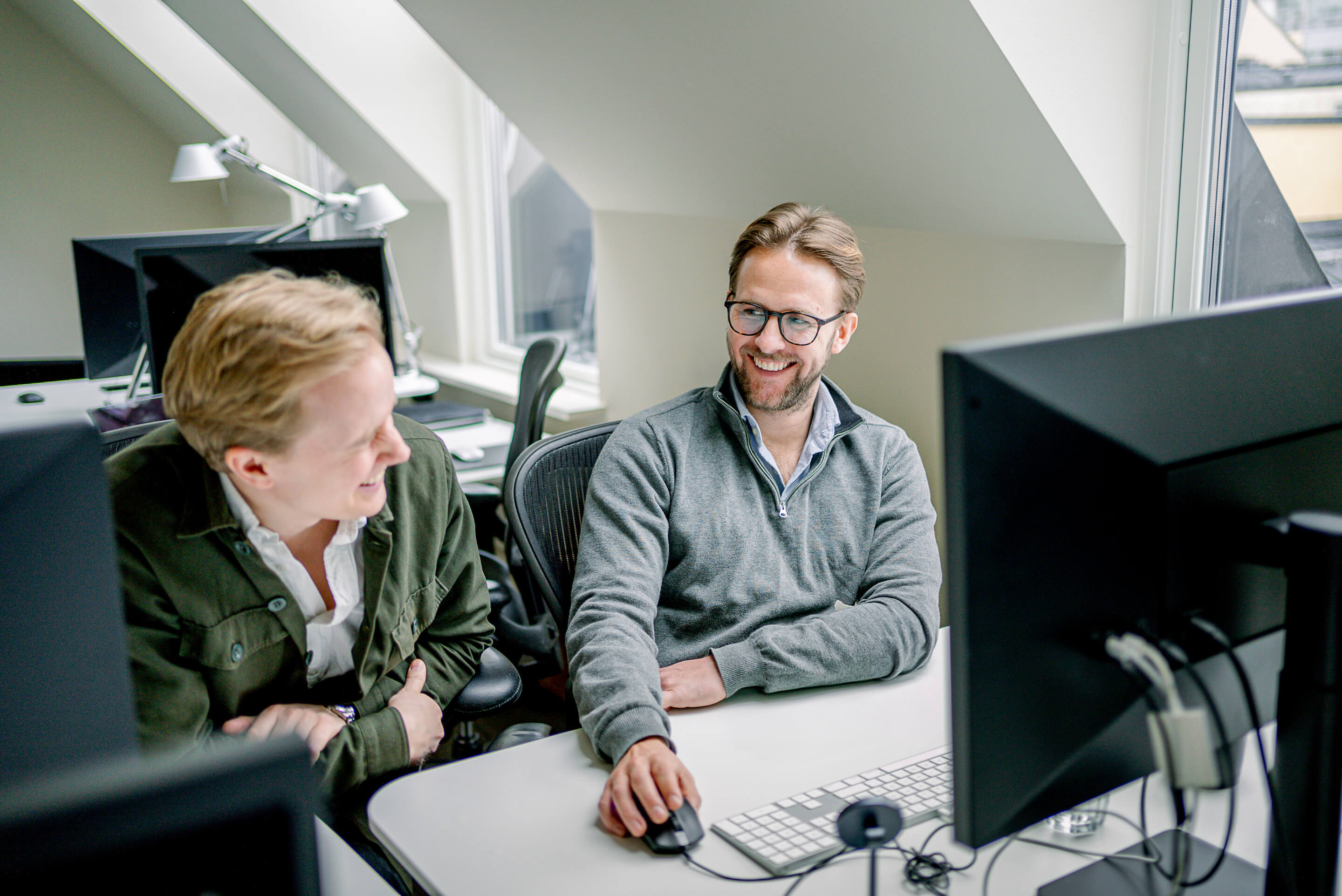 Two Exelement colleagues in a strategy meeting in front of computers focusing on collaboration and planning