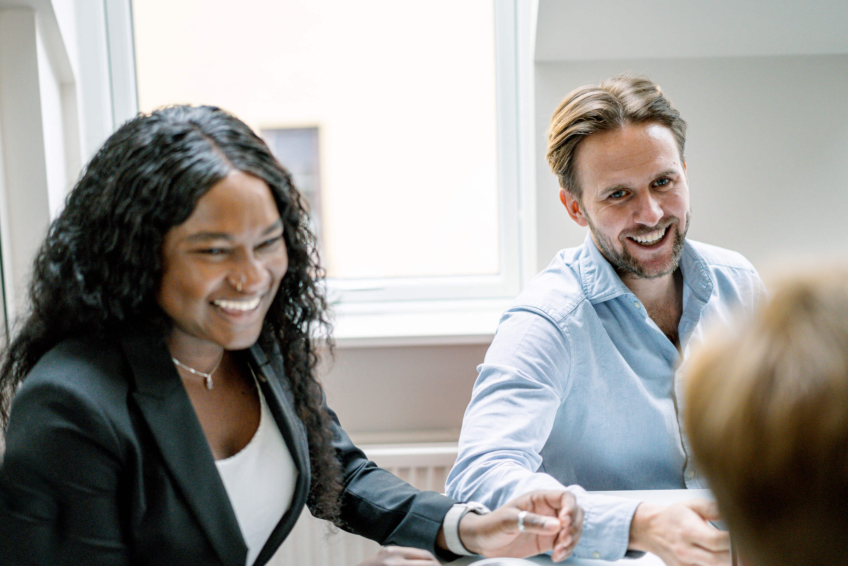 Exelement colleagues collaborating in a meeting smiling and discussing ideas
