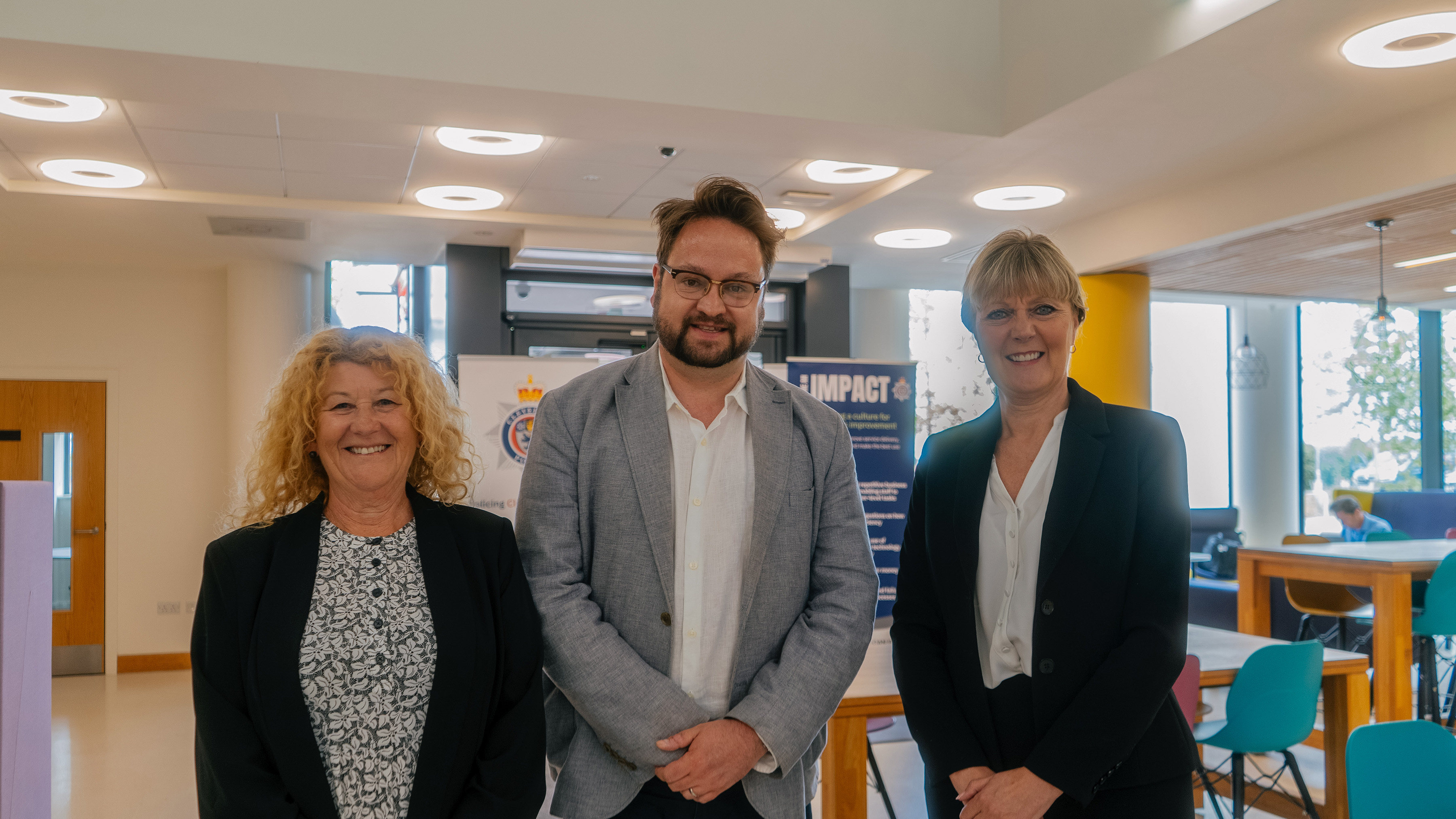 Three people standing together in a room