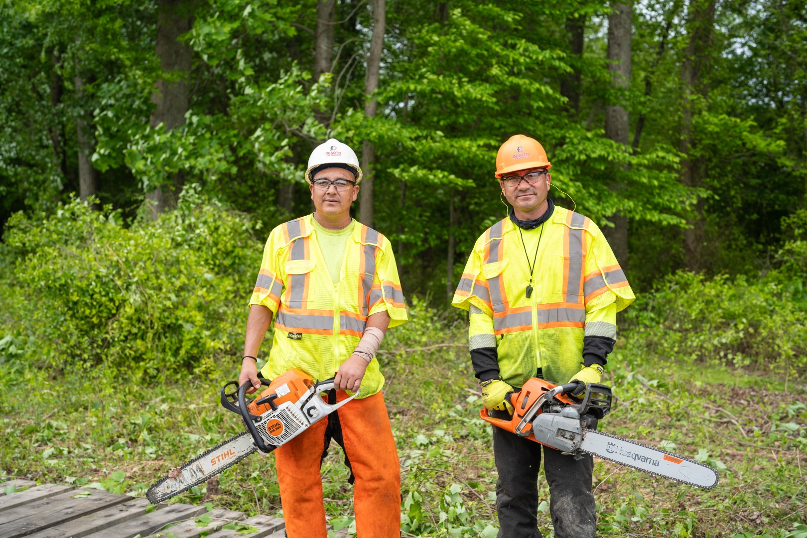  Posed photo of construction workers wearing hard hats and carrying power tools during video production for the Desoto Group.
