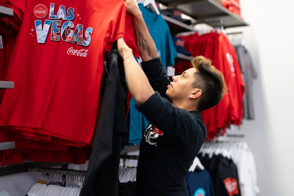  Coca-Cola employee working with merchandise for a training video.