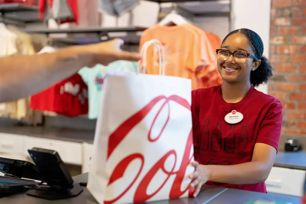 Coca-Cola employee assisting customer for the filming of an employee training video.