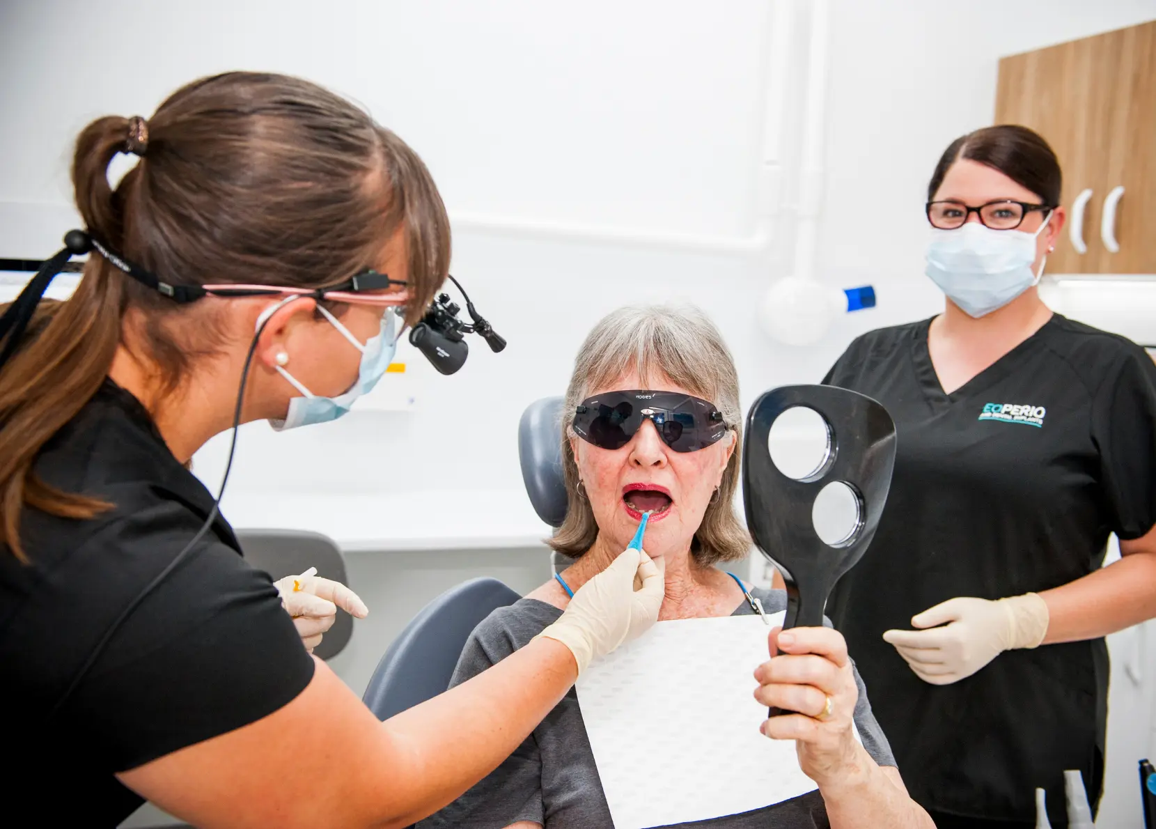 An oral health therapist teaches the patient how to use interdental brushes effectively at EO Perio.