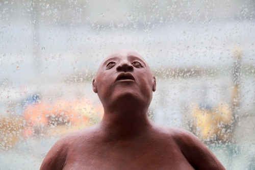 A small clad figure looking up to the sky.