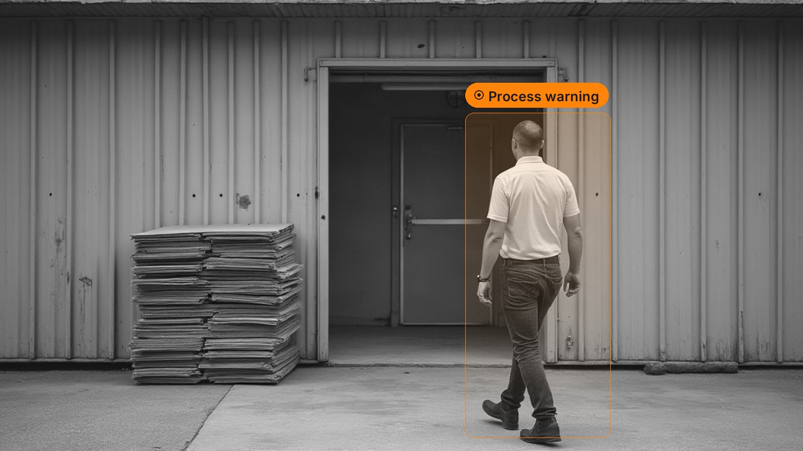 An employee walking toward the rear service door of a store, flagged with a process warning region
