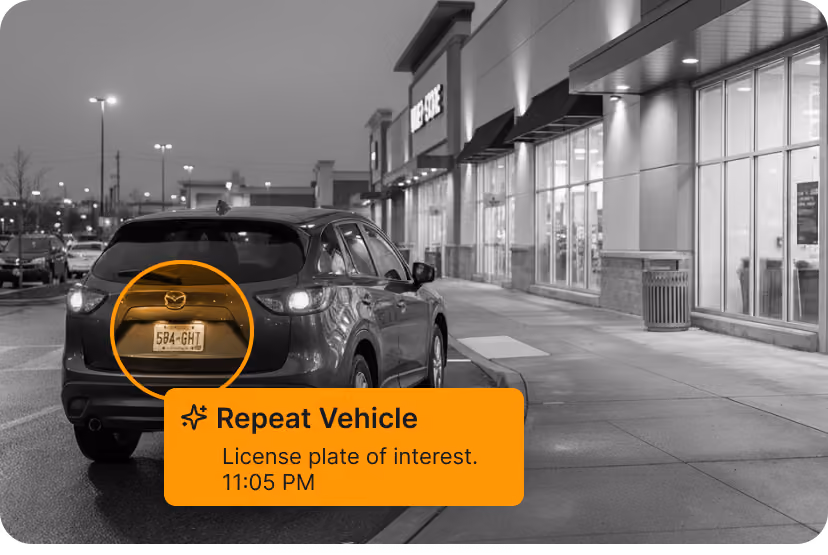 Rear view of a dark SUV parked near a store entrance at night with license plate highlighted.