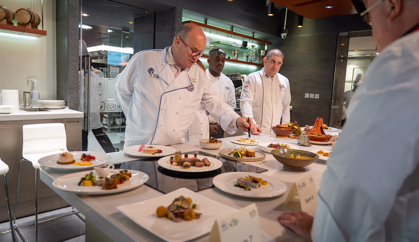 A group of chefs preparing food in a kitchen.