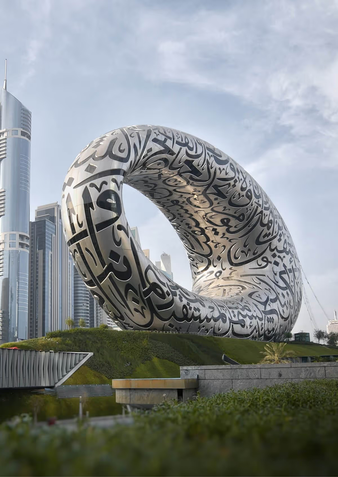 A large white sculpture in front of a tall building.
