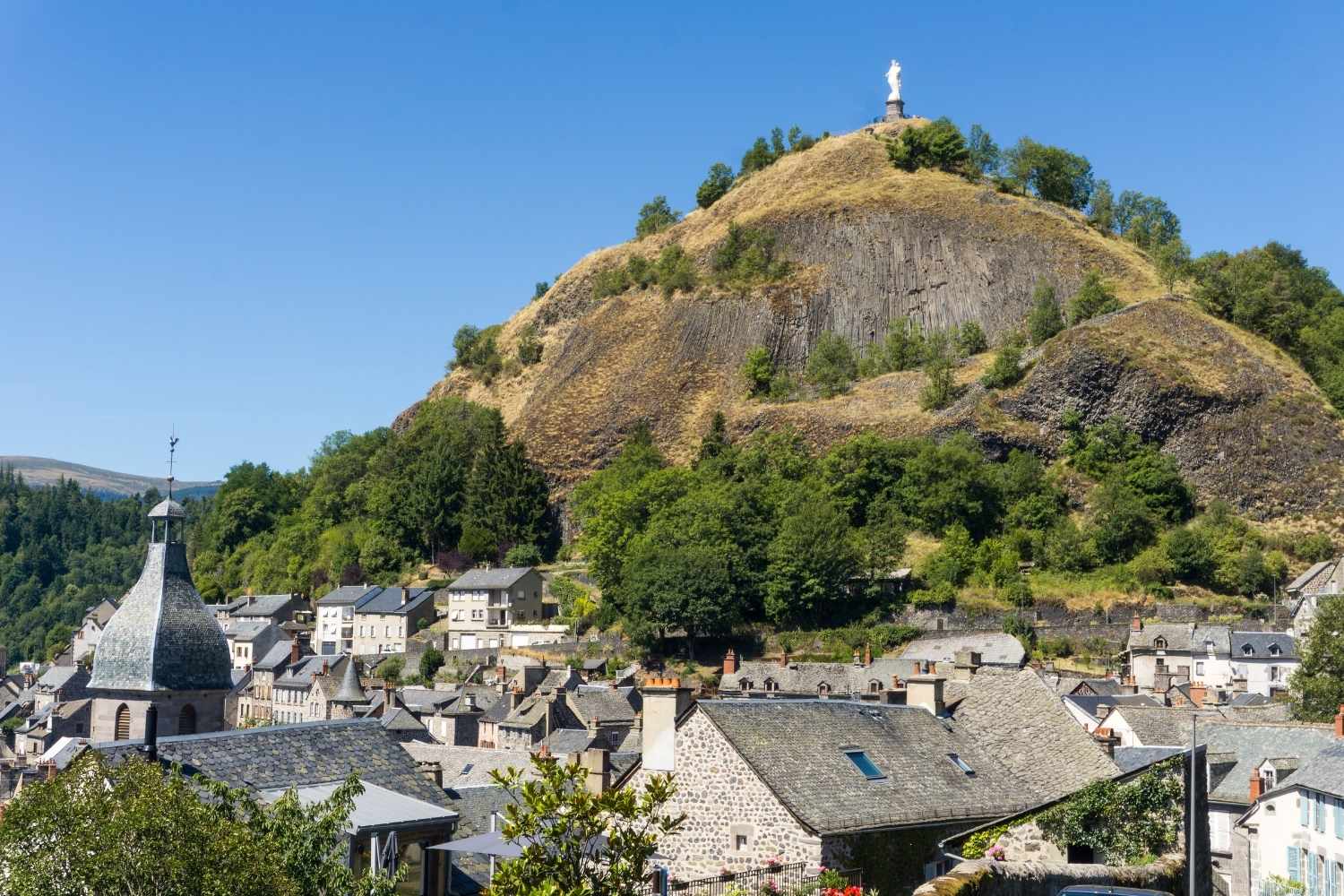 Vue sur le Rocher depuis Murat, La collégiale Notre-Dame des Oliviers à Murat, une destination accessible en train en Auvergne