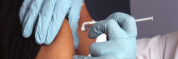 A nurse giving an immunization in the upper arm