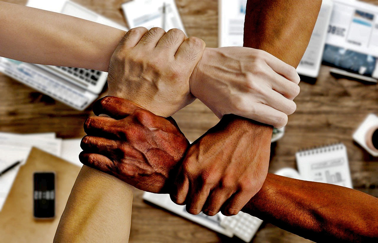 Imagem de uma equipe de trabalho dando suas mãos