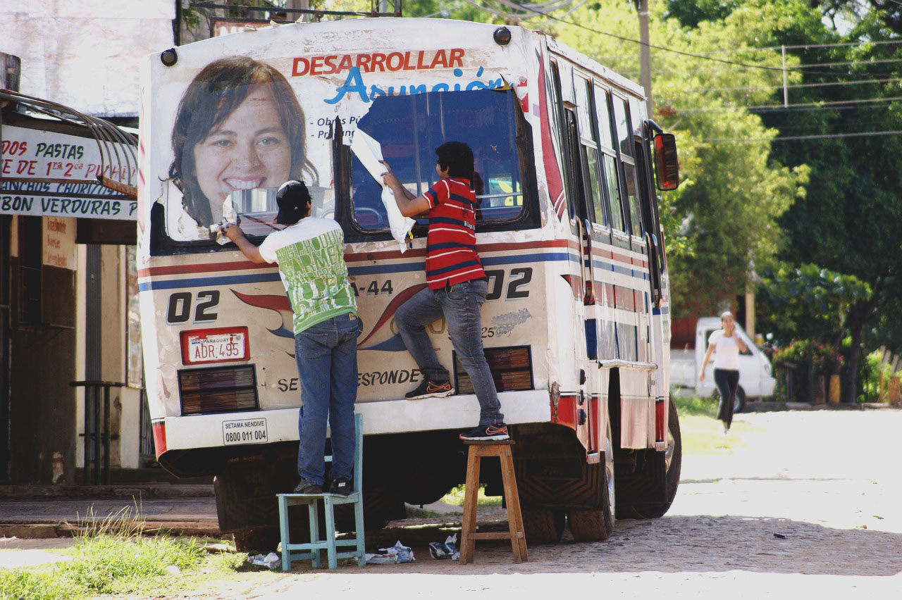 Imagem de duas pessoas decorando um ônibus no Paraguai