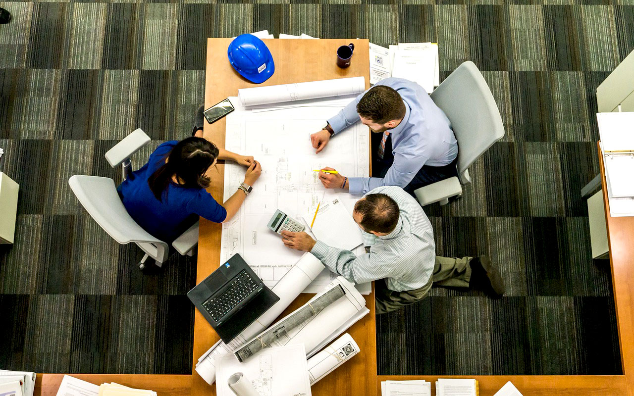 Imagem de engenheiros e arquitetos estudando uma planta de um projeto
