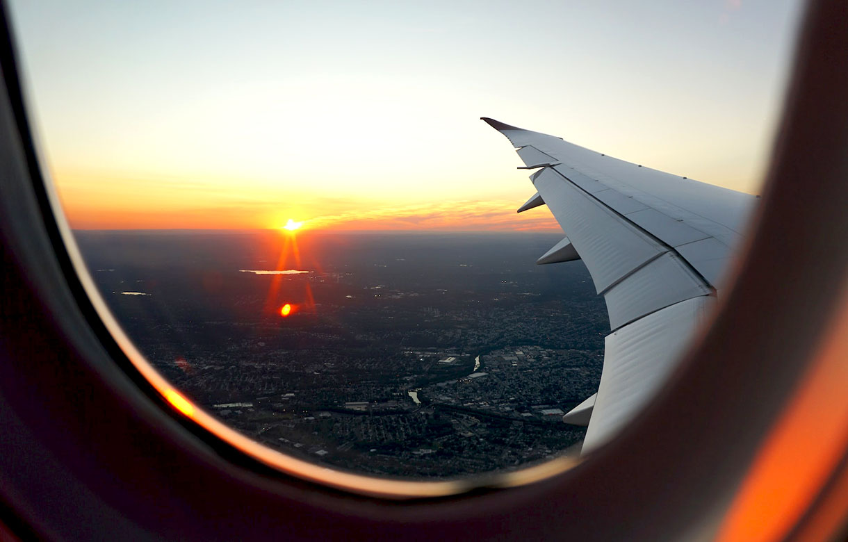 Imagem da janela de um avião com a vista da cidade