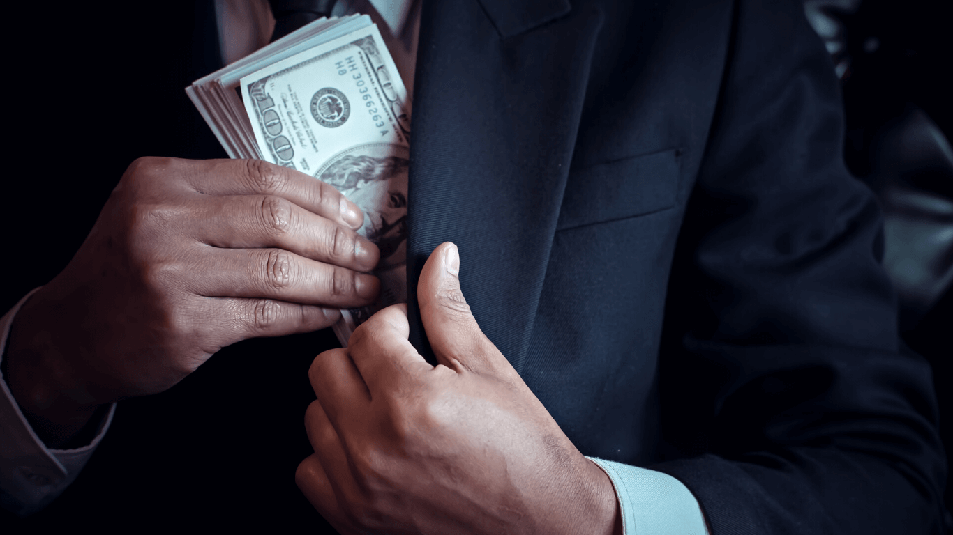 Homem colocando dinheiro dentro do paletó