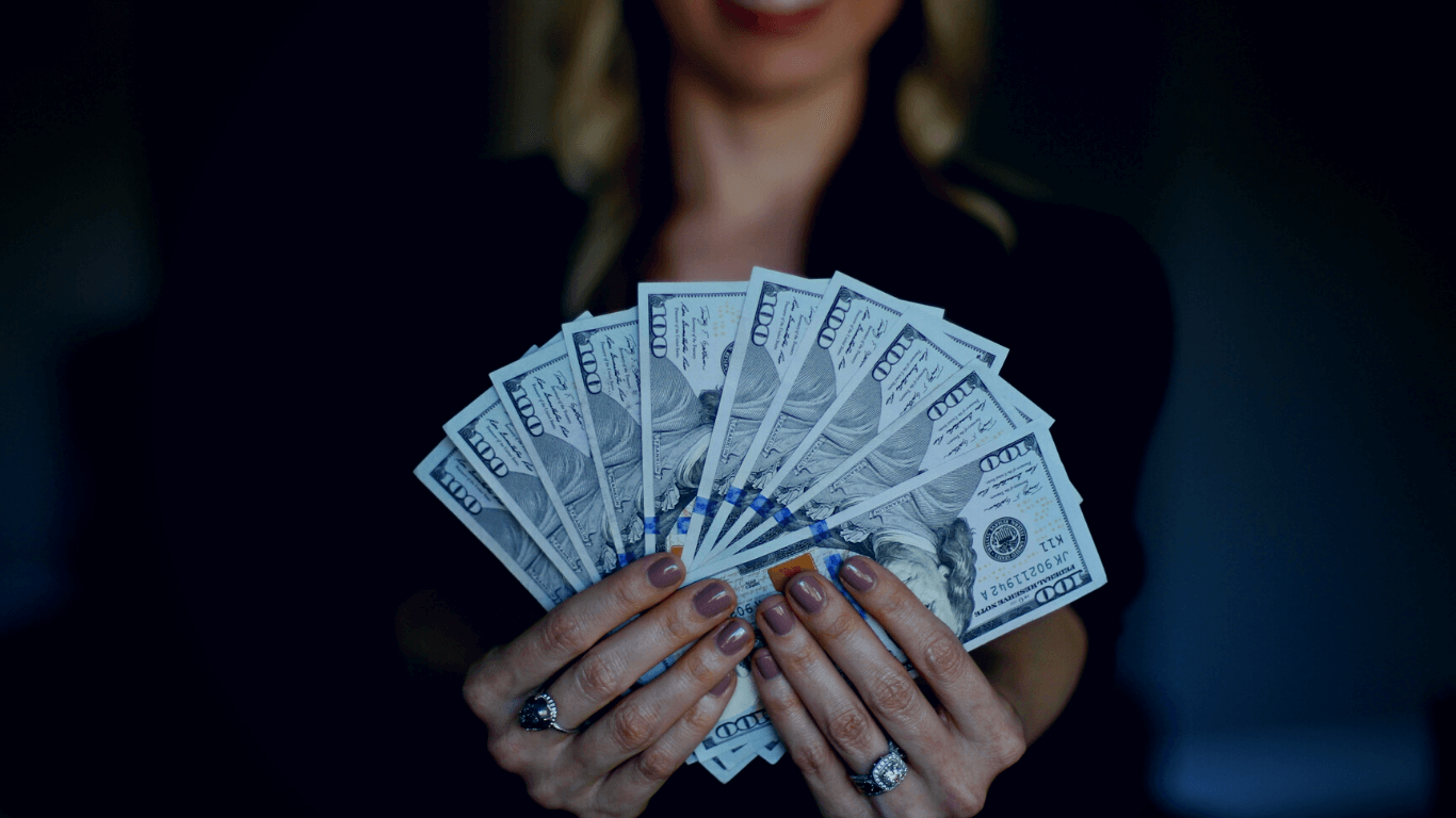 Mulher empresária segurando várias notas de dólares