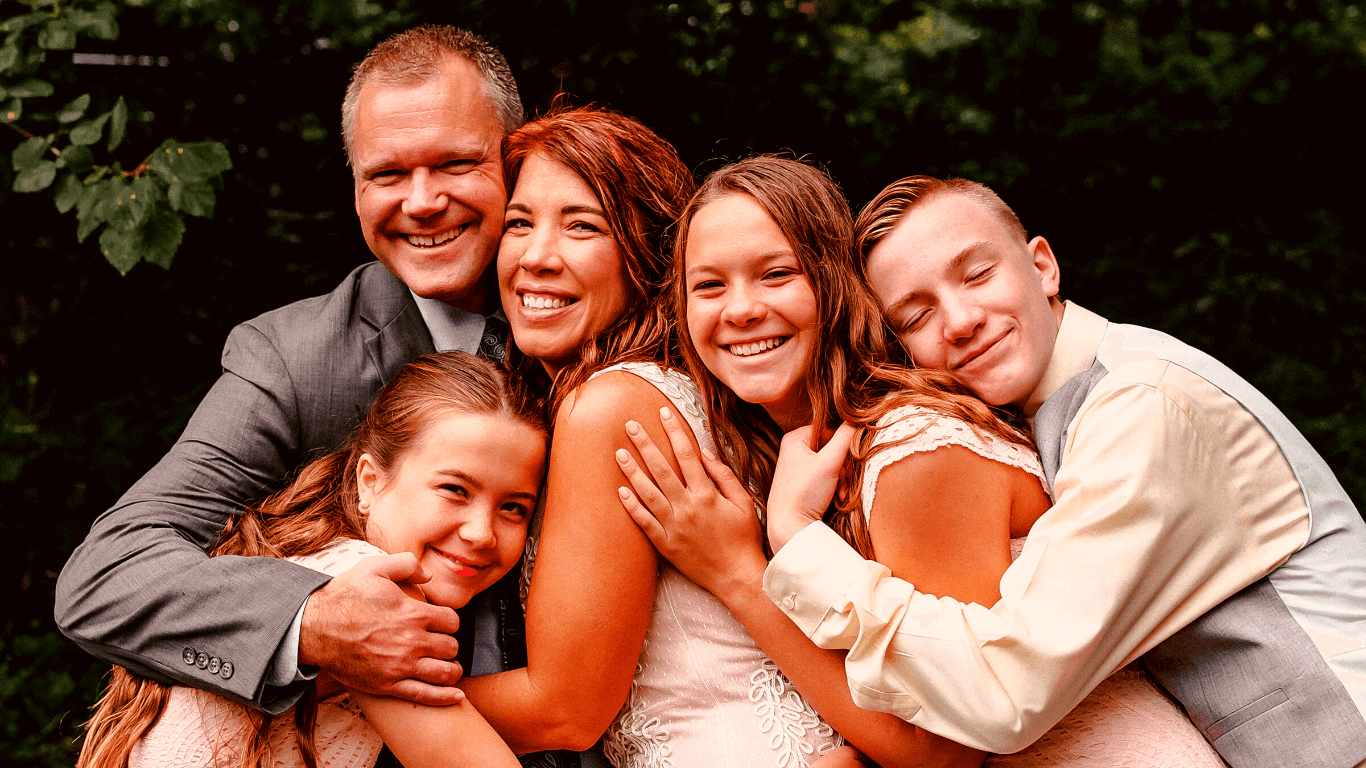 Família com 3 filhos se abraçando
