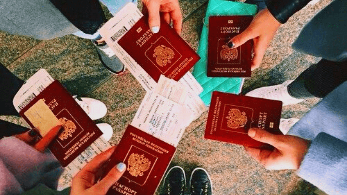 5 pessoas em círculo com passaporte vermelho na mão e tickets de viagem