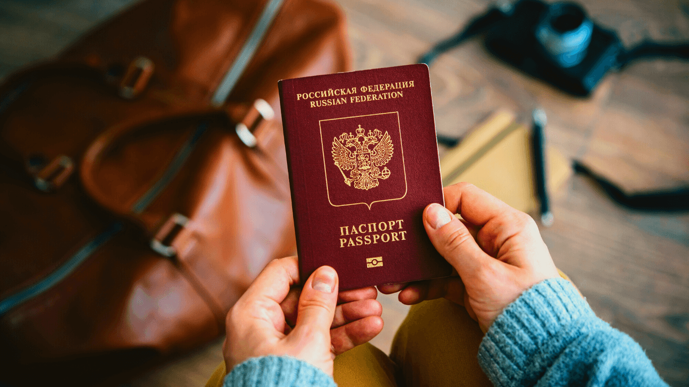 Pessoa segurando um passaporte russo vermelho indo viajar