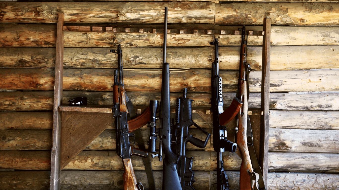 armas encostadas em uma parede de madeira