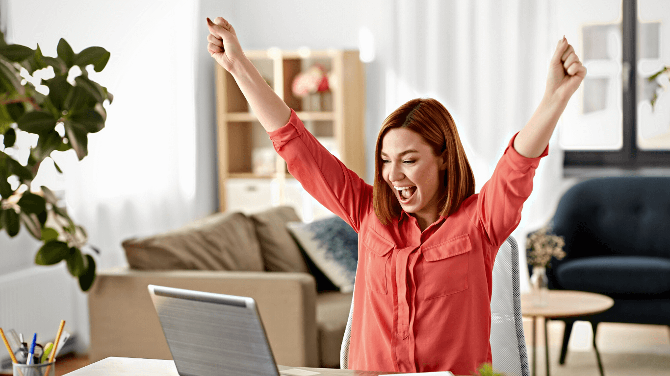 Mulher comemorando em frente ao computador