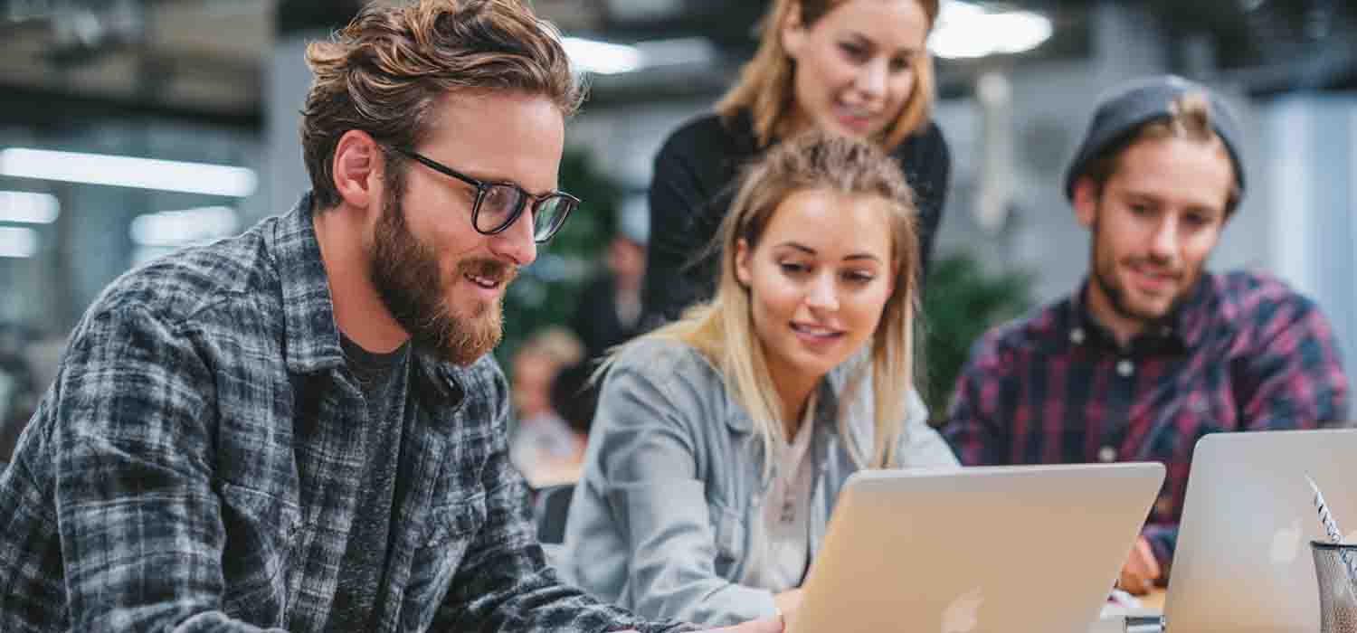Business team configuring Mac integration basics on Apple laptops in an office environment