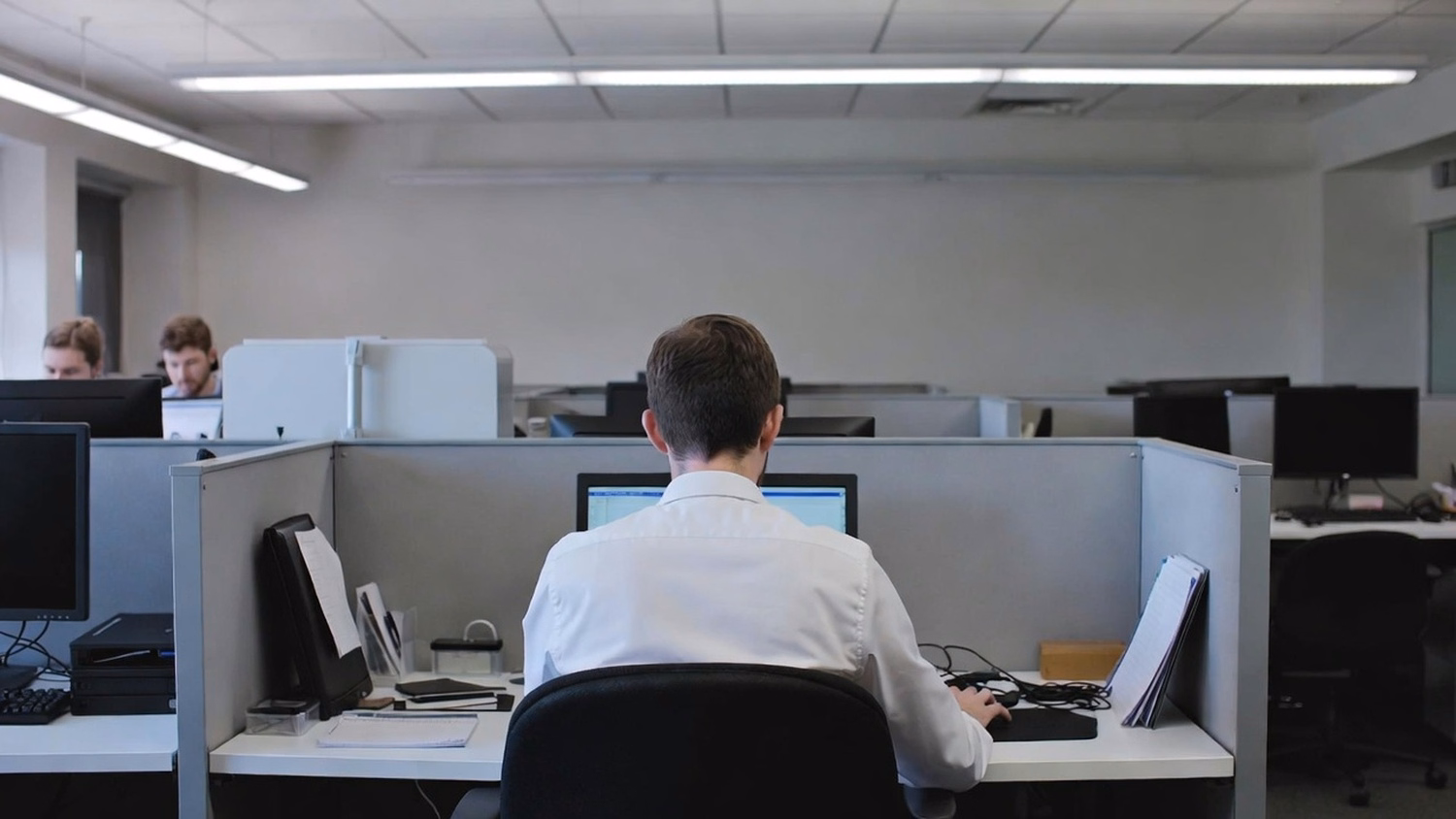 SOLO WORKSTATION An IT professional one person alone at a single desk with a