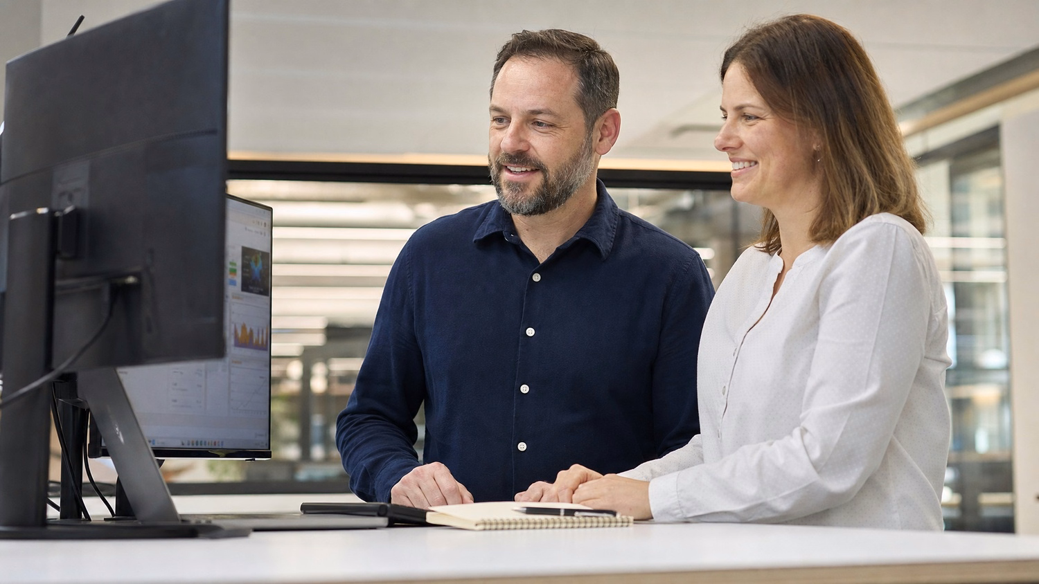 Two professionals review computer screen, Intune management