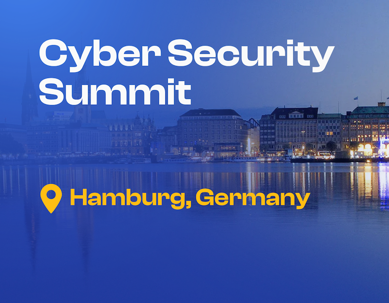 Eine Luftaufnahme der Stadt Hamburg mit historischen Backsteingebäuden entlang eines Kanals und einem markanten Kirchturm im Vordergrund, während in der Ferne der Industriehafen zu sehen ist. Das Bild ist mit dem Text „Cyber Security Summit“ und einem gelben Standort-Pin-Symbol mit der Aufschrift „Hamburg, Deutschland“ überlagert.