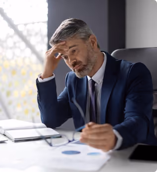 Zmartwiony manager siedzący przy biurku 