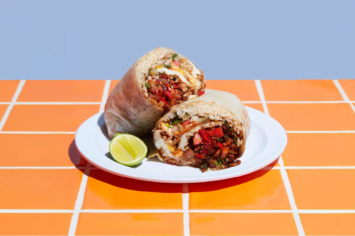 Tiki Taco feast spread featuring burritos, street corn, and horchata drinks on a table