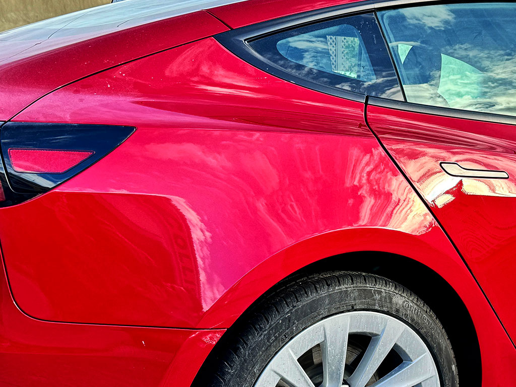 Red Tesla Model 3 rear quarter panel after repair and paint