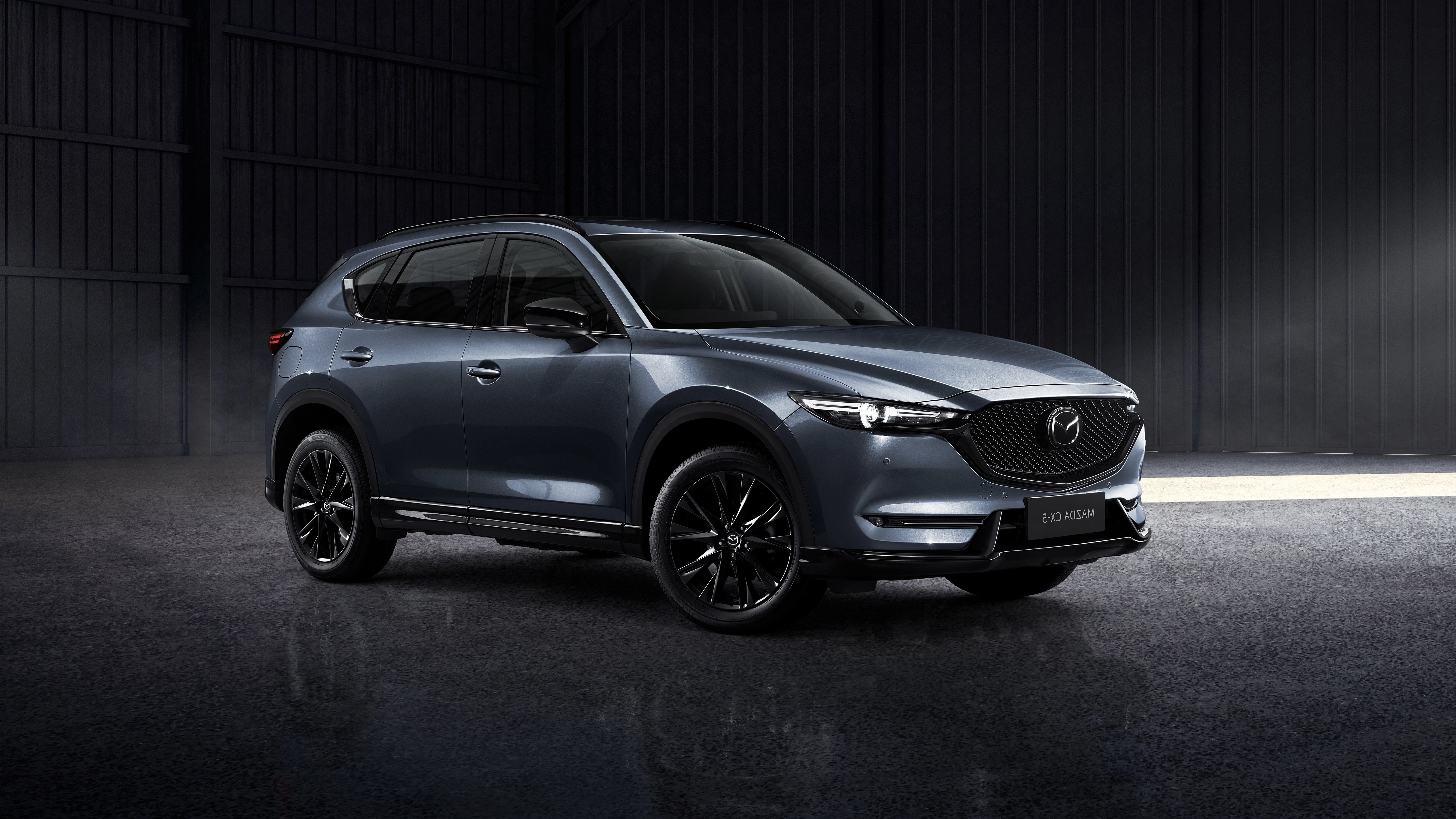 Gray Mazda CX-5 SUV in a dark studio