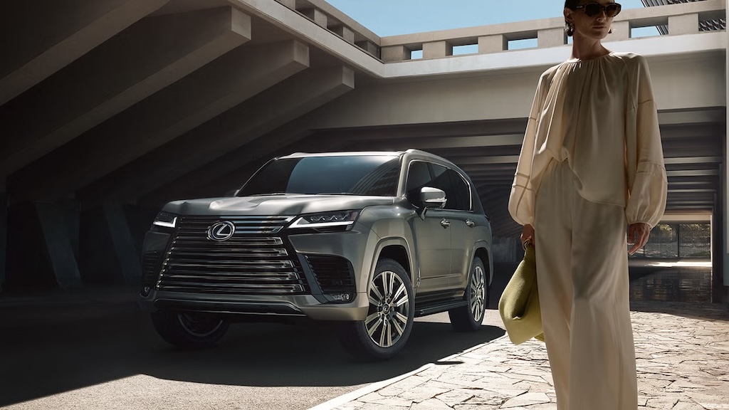 Dark green Lexus LX SUV parked under a concrete canopy
