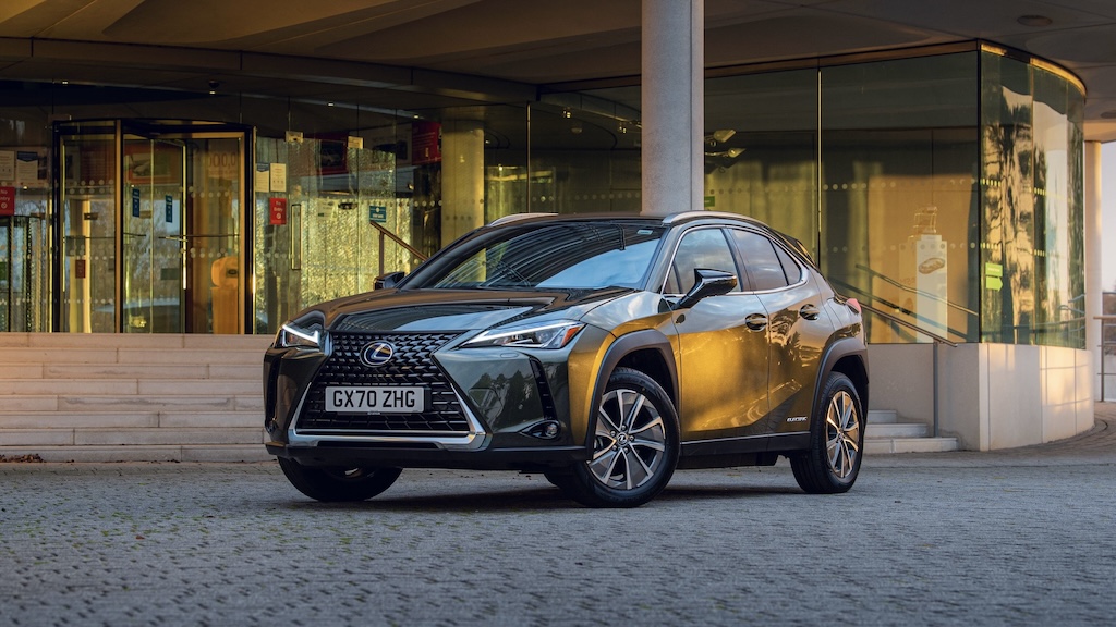 Bronze Lexus UX crossover parked outside a glass building