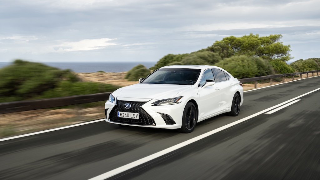 White Lexus ES sedan driving on a coastal highway