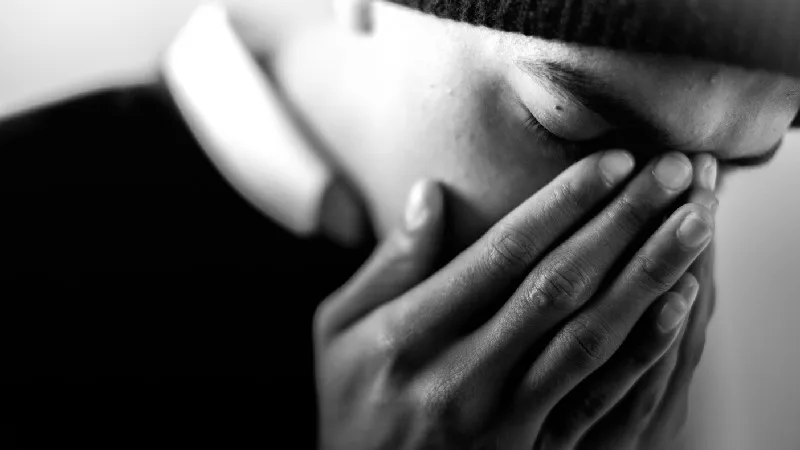 Man praying with his face in his hands