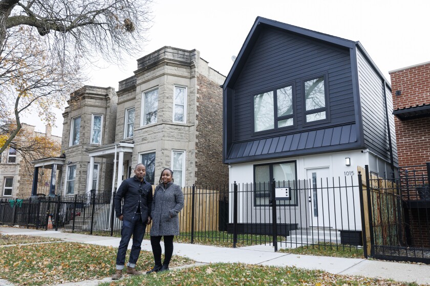 Bill Williams, founder and principal at KMW Communities, and Lynnette McRae, program director for Connecting Capital and Community, stand outside a recently built home in Humboldt Park. The executives are part of a group helping to build new homes and provide resources that help first time homebuyers on the West Side.