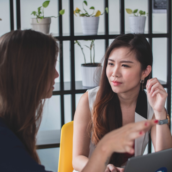 Two women talking during a meeting