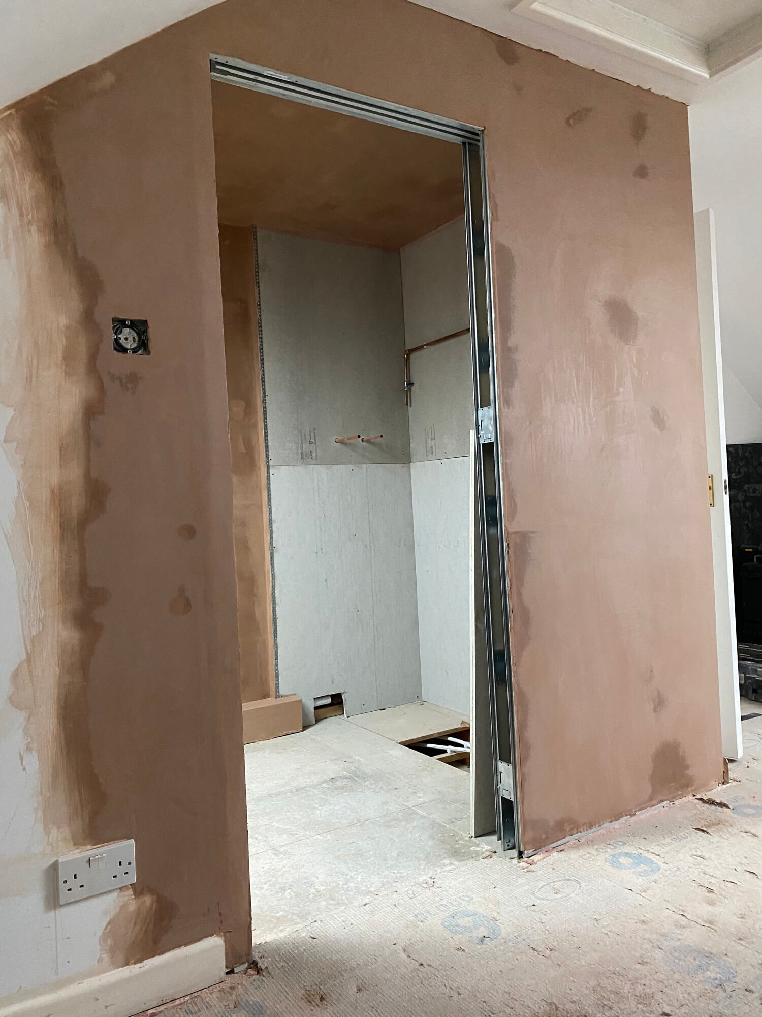 Bathroom wall being constructed and plastered.