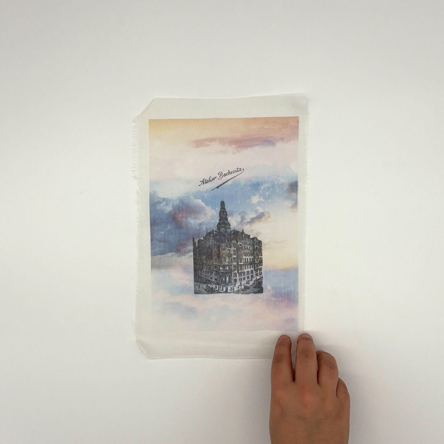 A studio photo of a designer bag and a publication printed on textile